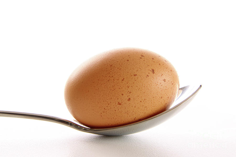 Brown egg with spoon on white Photograph by Sandra Cunningham