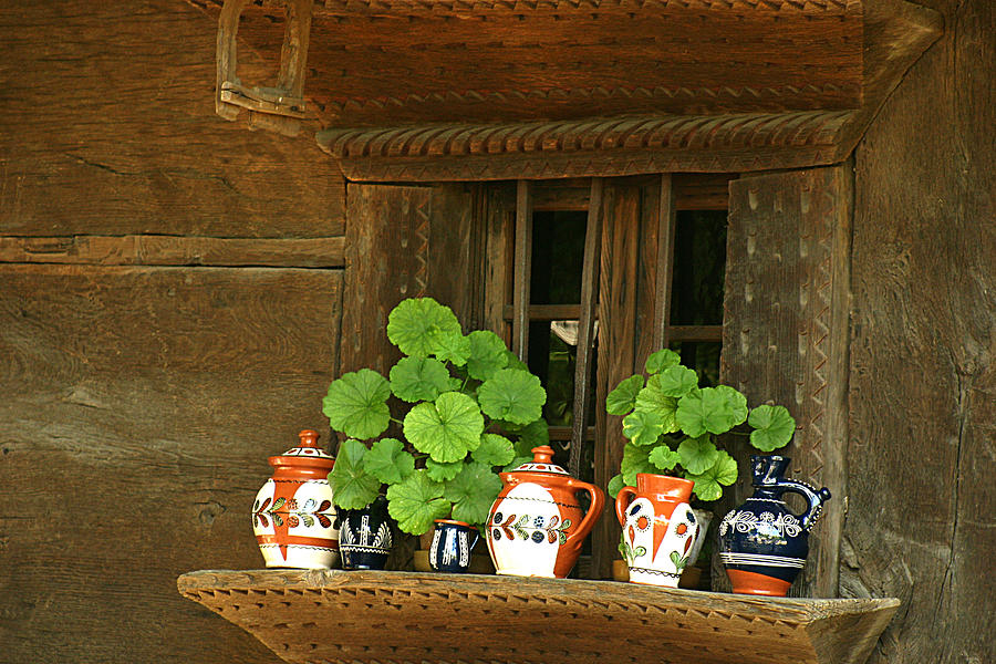Ceramic jugs and geraniums at the window Photograph by Emanuel Tanjala