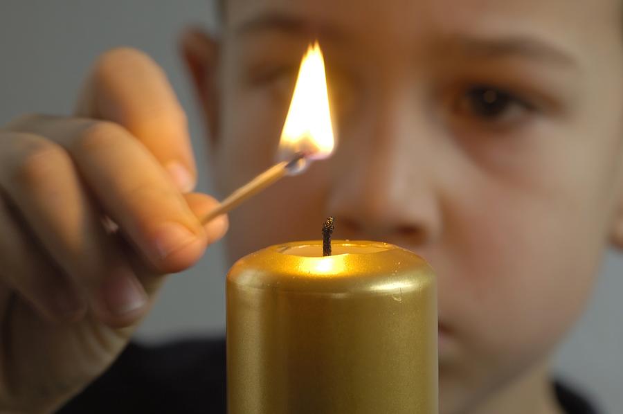 Child lights a candle Photograph by Matthias Hauser