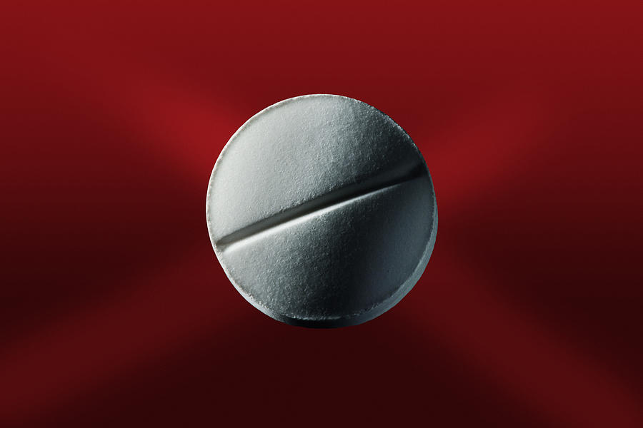 Close Up Of Pill On Red Surface Photograph by Opticopia