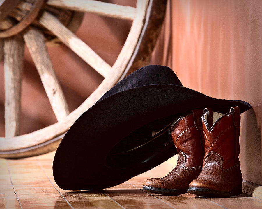 hat leaning on boots Photograph by - Fine Art America