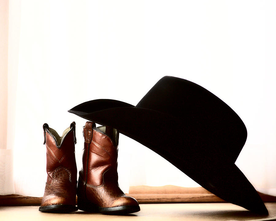 Cowboy hat leaning on small boots Photograph by Mark Duffy