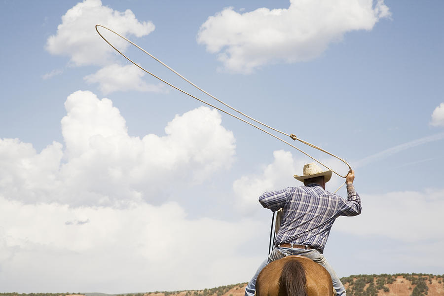 Cowboy On Horseback Swinging Lasso, Rear View Photograph by Andrew Geiger