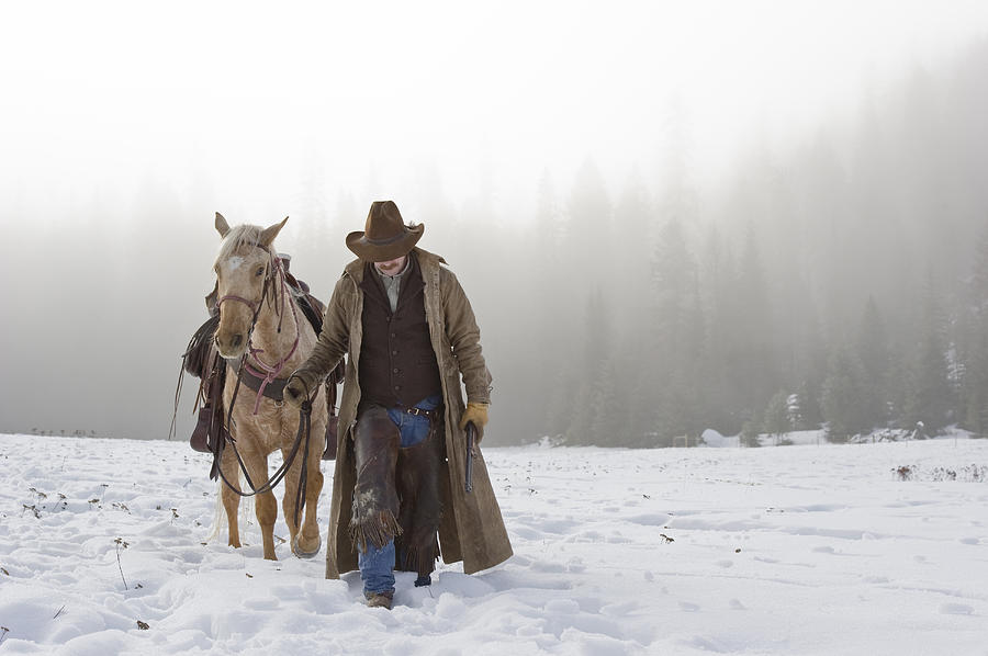 Cowboy Walking His Horse And Holding A Shotgun Photograph by Thomas Kokta