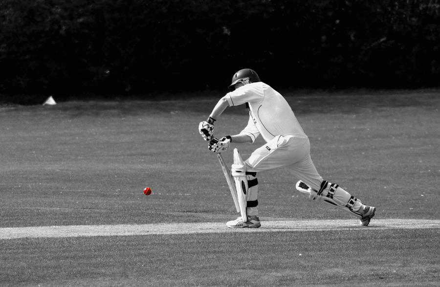 Cricketer in black and white with red ball Photograph by Chris Day
