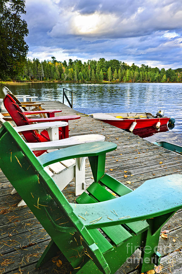 Fall Photograph - Deck chairs on dock at lake by Elena Elisseeva