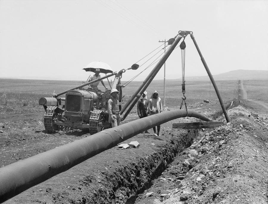 Desert Photograph - Dropping A Welded Pipe Into A Trench by Everett