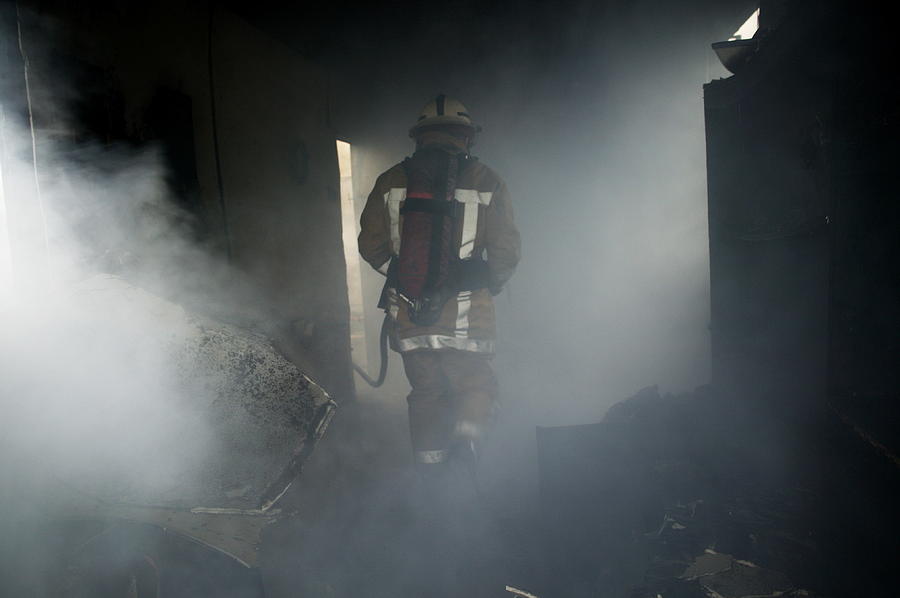 Clothing Photograph - Fire Fighter In A Burnt House by Michael Donne