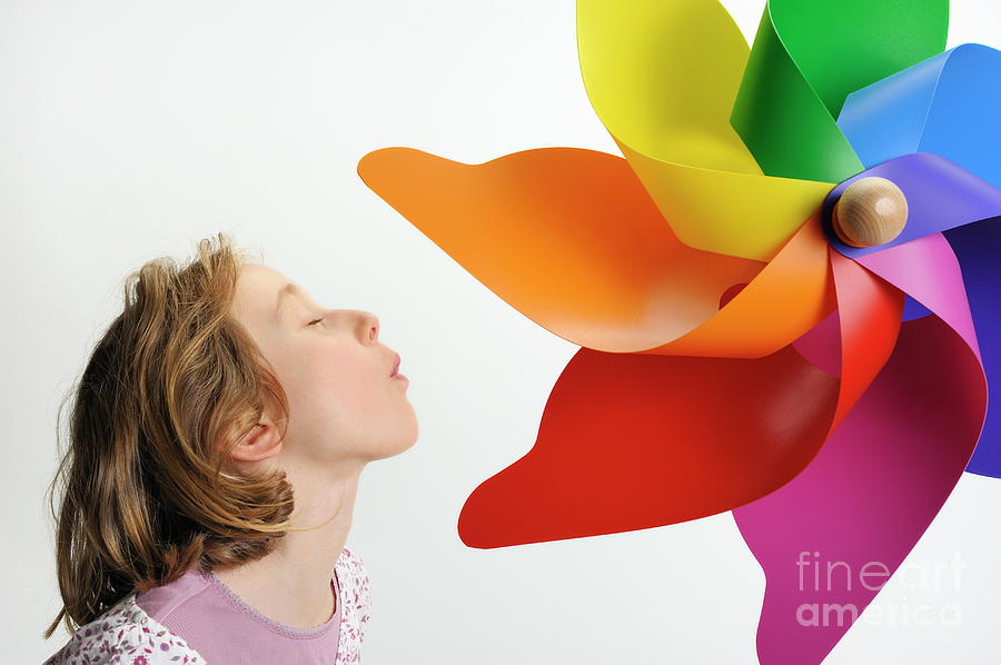 Girl blowing on a colorful windmill Photograph by Sami Sarkis