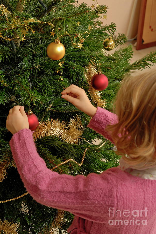 Girl decorating Christmas tree Photograph by Sami Sarkis