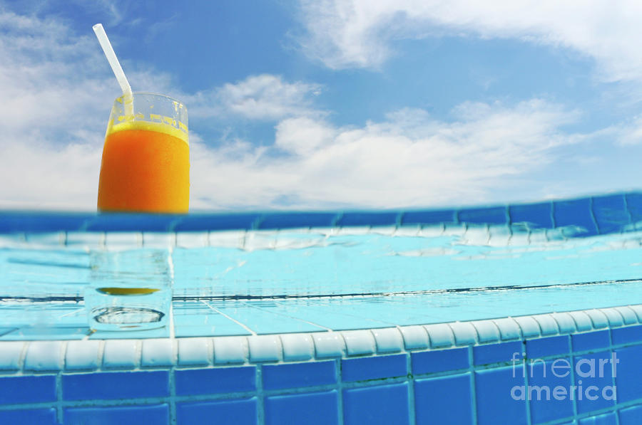 Freshness Photograph - Glass of orange juice on pool ledge by Sami Sarkis