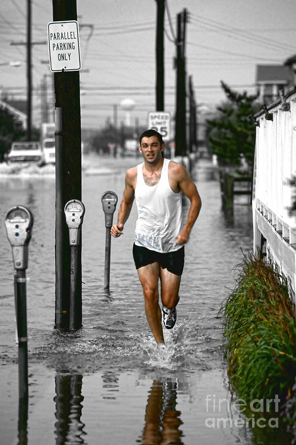 Young Man Running Along a Flooded Sidewalk Photograph by William Kuta