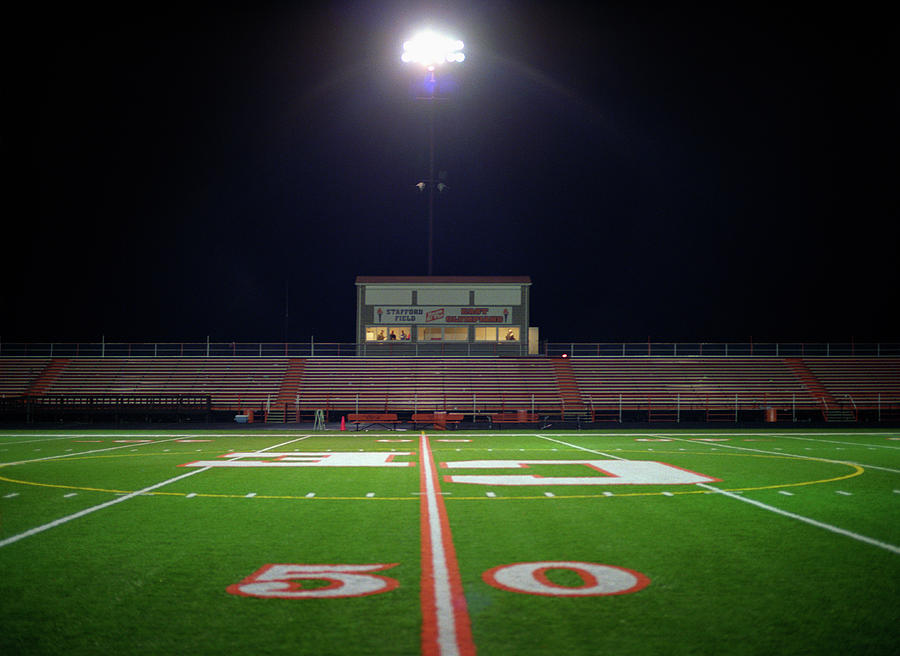 illuminated american football field at night darrin klimek