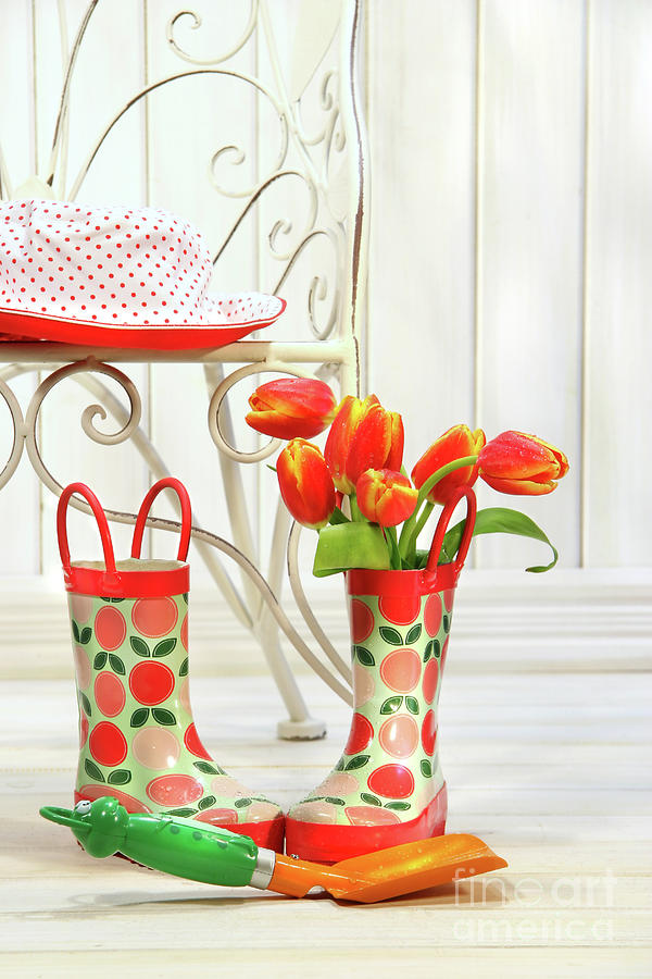 Nature Photograph - Iron chair with little rain boots and tulips  by Sandra Cunningham