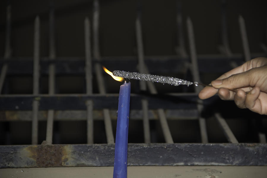 Lighting a sparkler with a candle as a part of Diwali celebrations Photograph by Ashish Agarwal