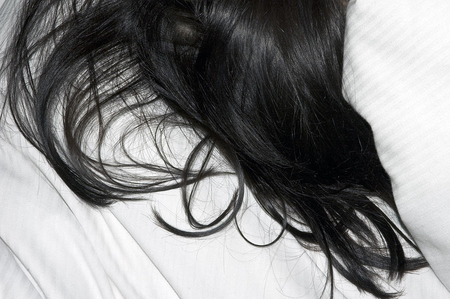 Long dark hair of a woman on white pillow Photograph by Matthias Hauser
