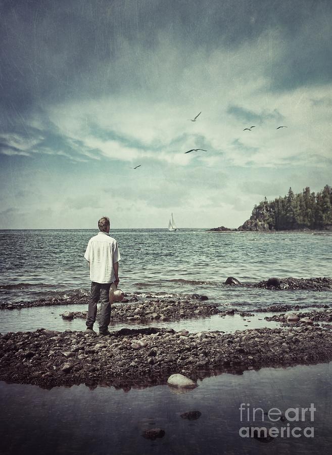 Man standing at waters edge looking out to sea Photograph by Sandra Cunningham