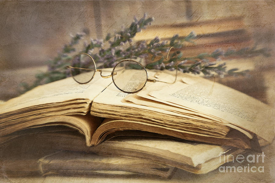 Old books open on wooden table by Sandra Cunningham