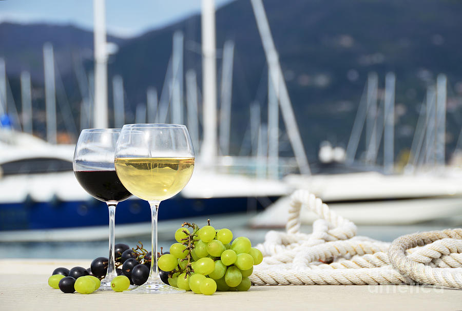Grape Photograph - Pair of wineglasses and grapes against the yacht pier of La Spezia by Alexander Chaikin