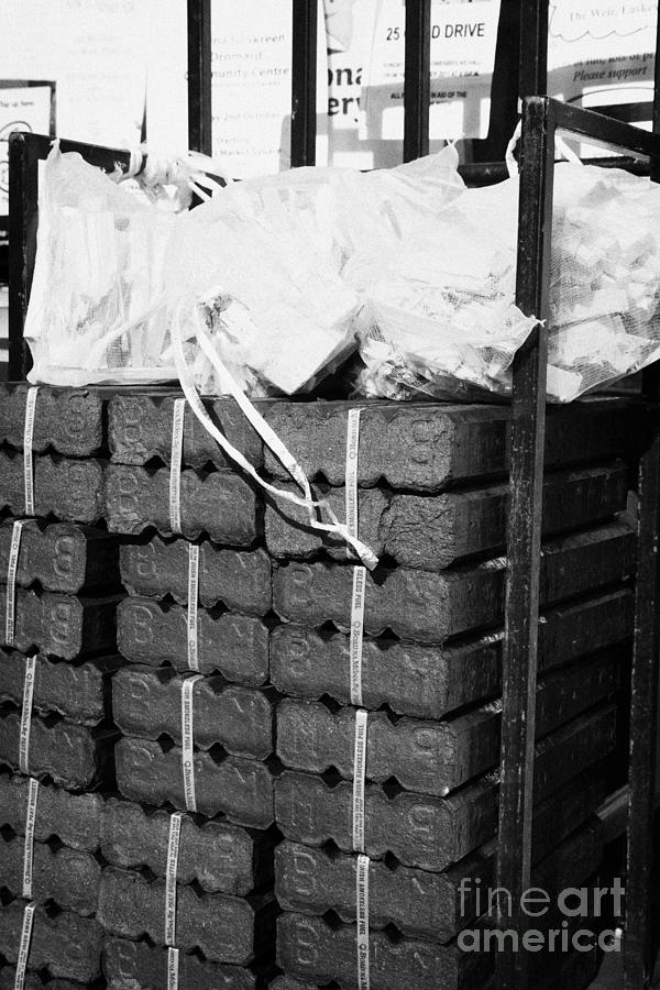 Pile Photograph - Pile Of Bord Na Mona Peat Briquettes With Sticks For Sale Outside A Shop In The West Of Ireland by Joe Fox