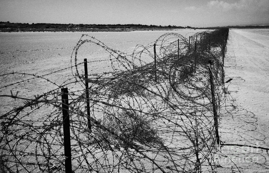 Rusty Photograph - rusty barbed wire fence on the akrotiri salt flats the limit of the western Sovereign Base Area by Joe Fox