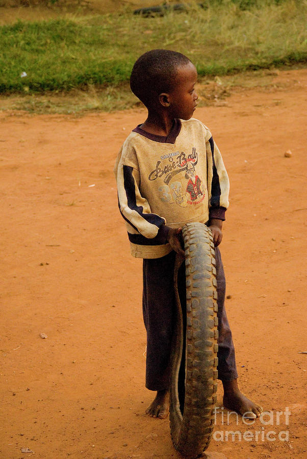 Rwandan boy with tire Photograph by Robert Suggs