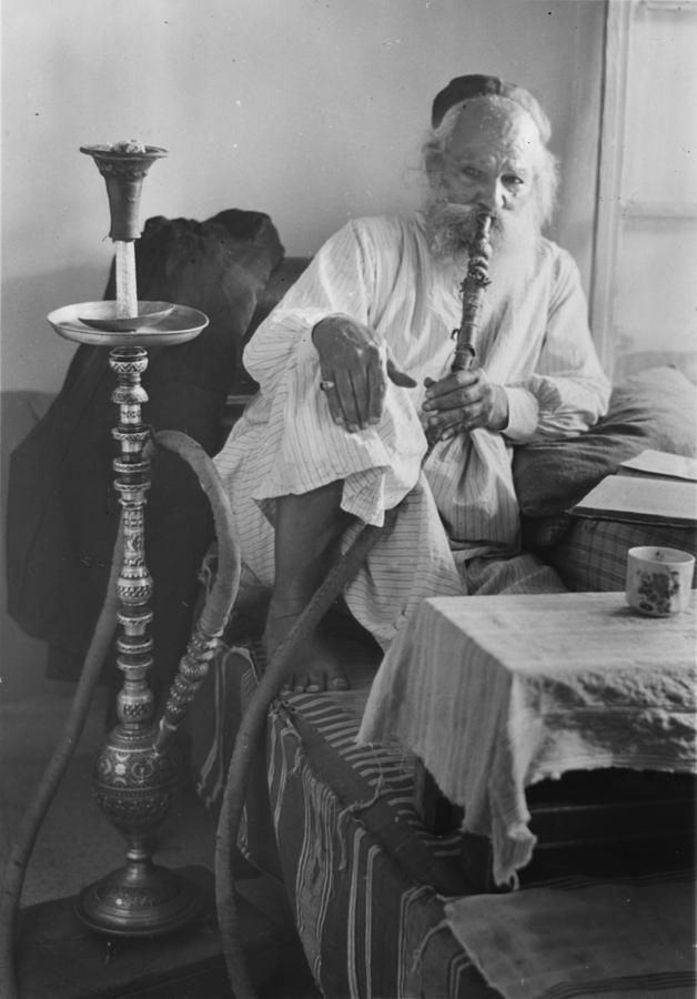 Portrait Photograph - Seated Man Smoking A Nargile, Or Water by Everett
