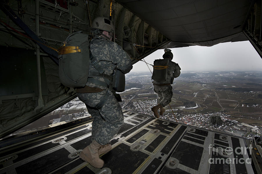 U.S. paratroopers jump out of a C-130 Hercules aircraft over