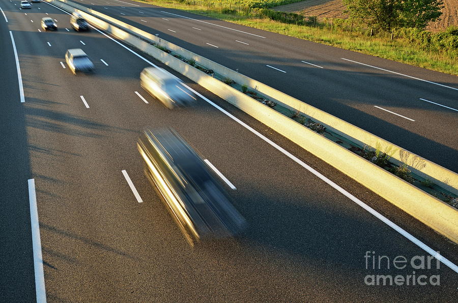 Speeding cars on highway at sunset Photograph by Sami Sarkis