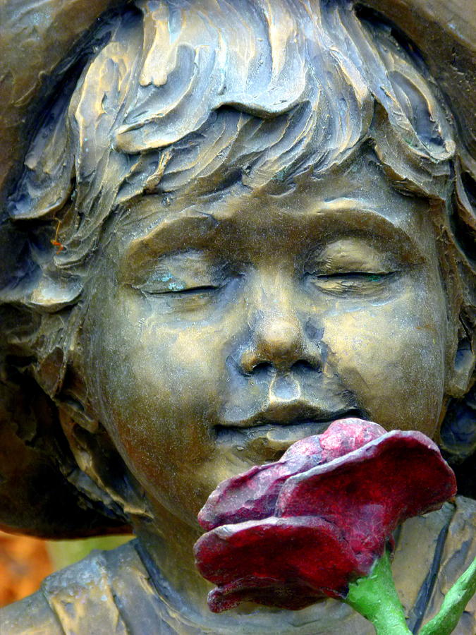 Statue of Child Smelling Red Rose Photograph by Jeff Lowe