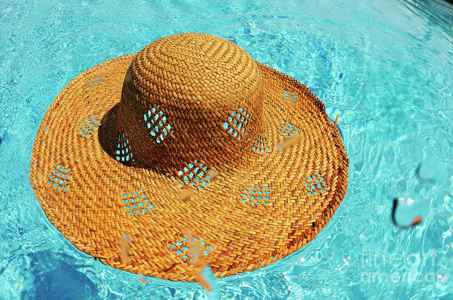 Straw hat floating on pool Photograph by Sami Sarkis