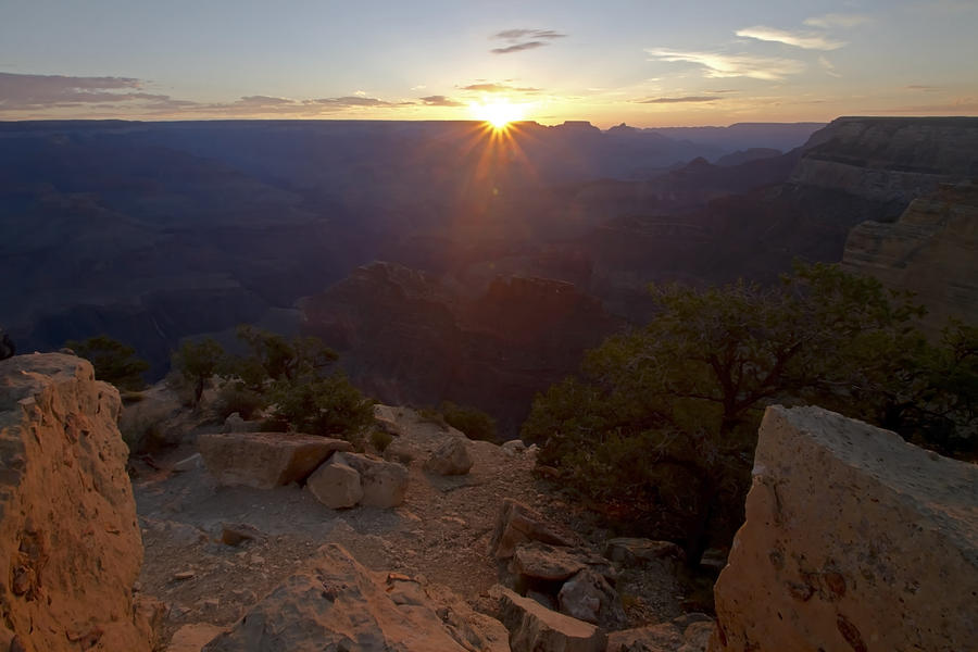 Sun peaks over the horizon at the Grand Canyon Photograph by Sven Brogren