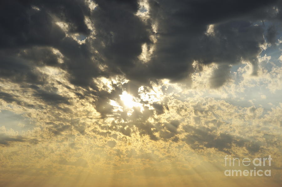 Sun shining through clouds at sunset Photograph by Sami Sarkis