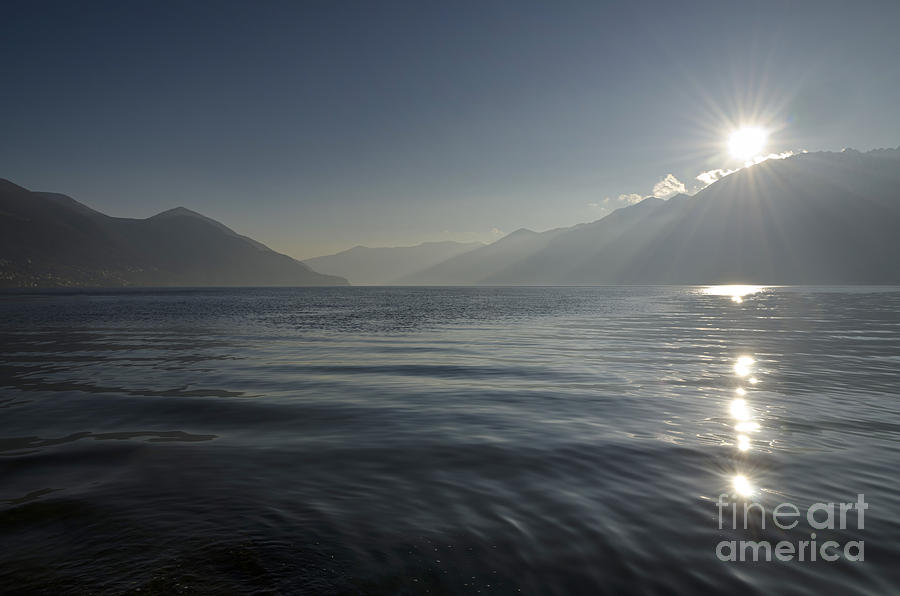 Sunlight over an alpine lake Photograph by Mats Silvan