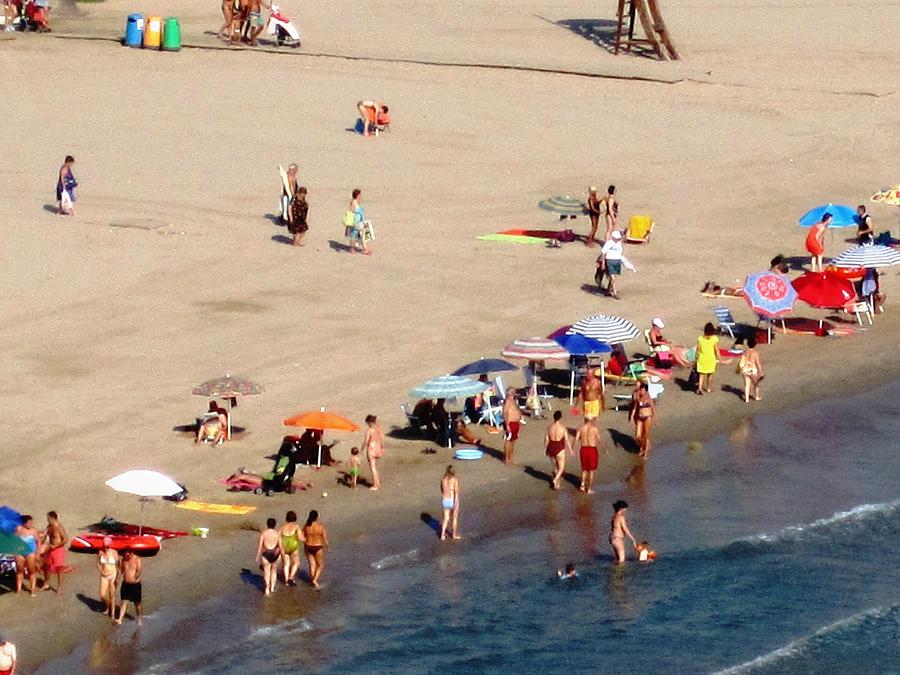 Swimming and Beach Umbrellas At Peniscola Beach Spain Photograph by John Shiron