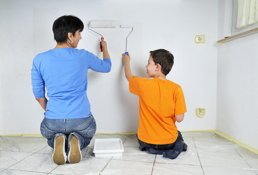 Teamwork - mother and son painting wall Photograph by Matthias Hauser