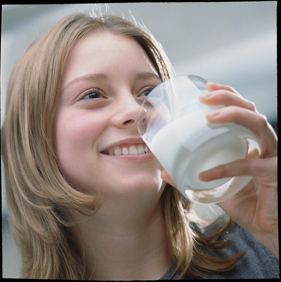 Girl Photograph - Teenage Girl Drinking A Glass Of Milk by Damien Lovegrove