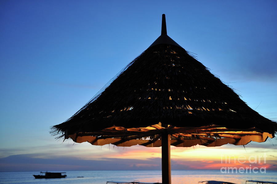 Thatched parasol on the beach at sunset Photograph by Sami Sarkis