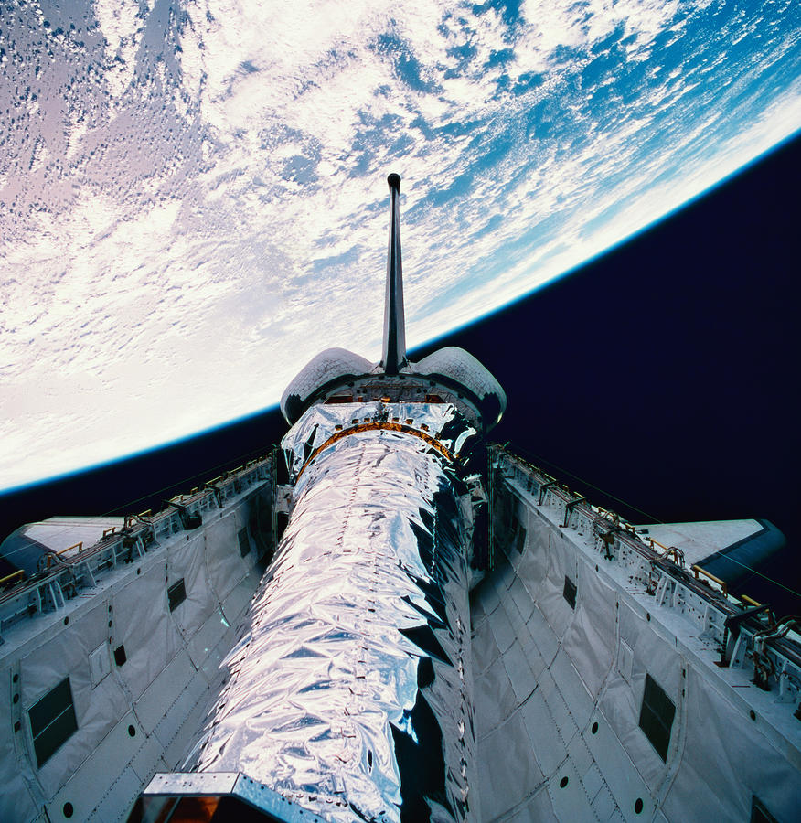 The Space Shuttle With Its Open Cargo Bay Orbiting Above The Earth Photograph by Stockbyte