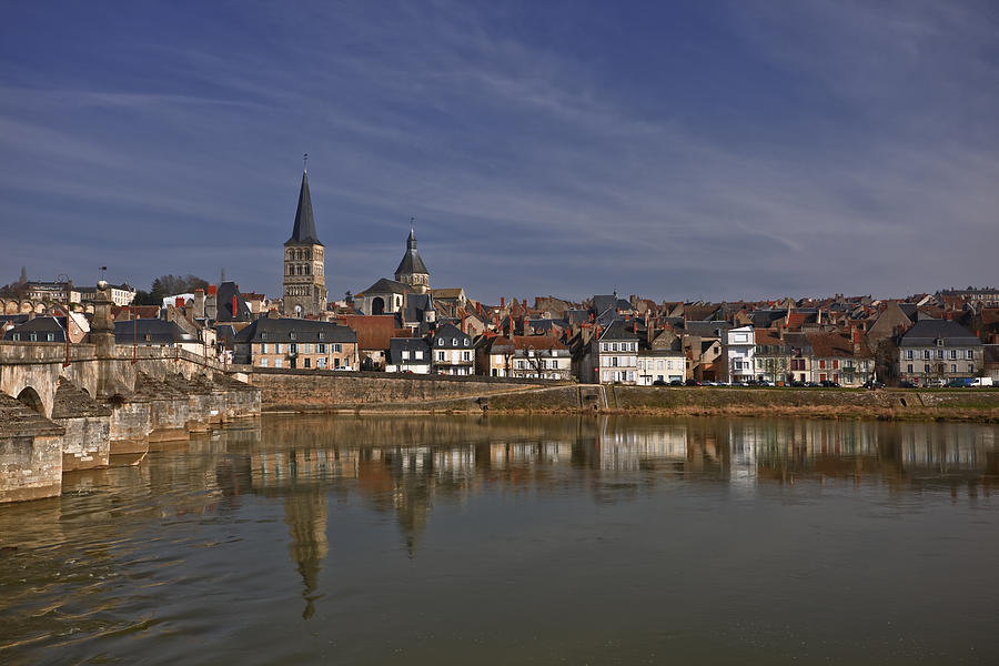 The Town Of La ChariteÃÂ©-sur-loire Reflected In The River Loire This Small Part Of France Is On The Fringes Of Burgundy Photograph by Julian Elliott Ethereal Light