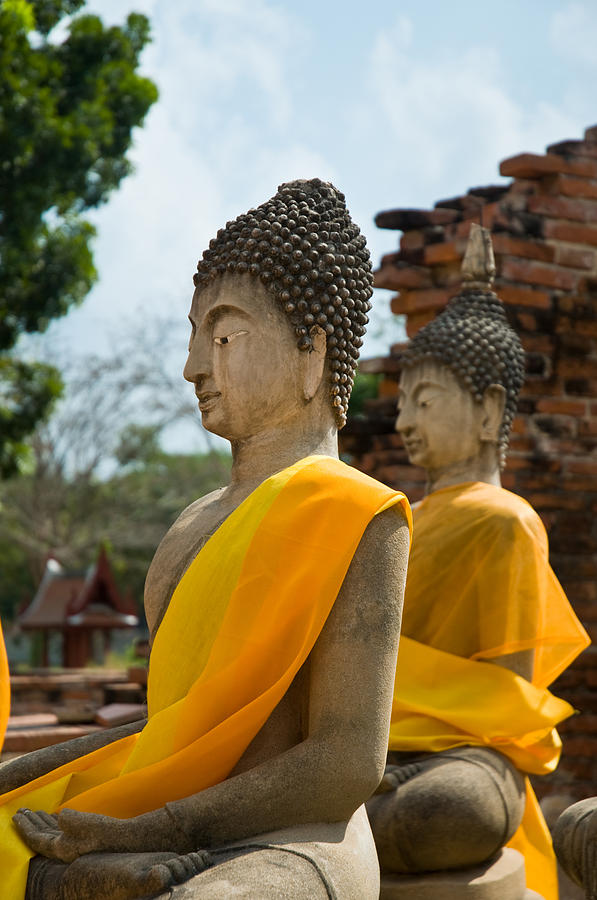 Two Buddha statues wrapped in an orange scarf  Photograph by U Schade
