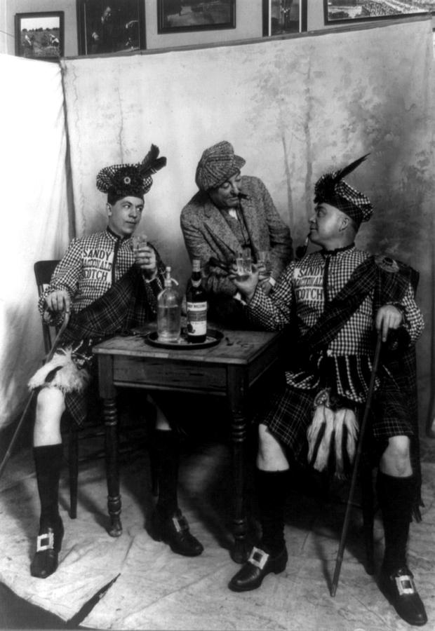 Two Men Wearing Kilts Seated At Small Photograph by Everett