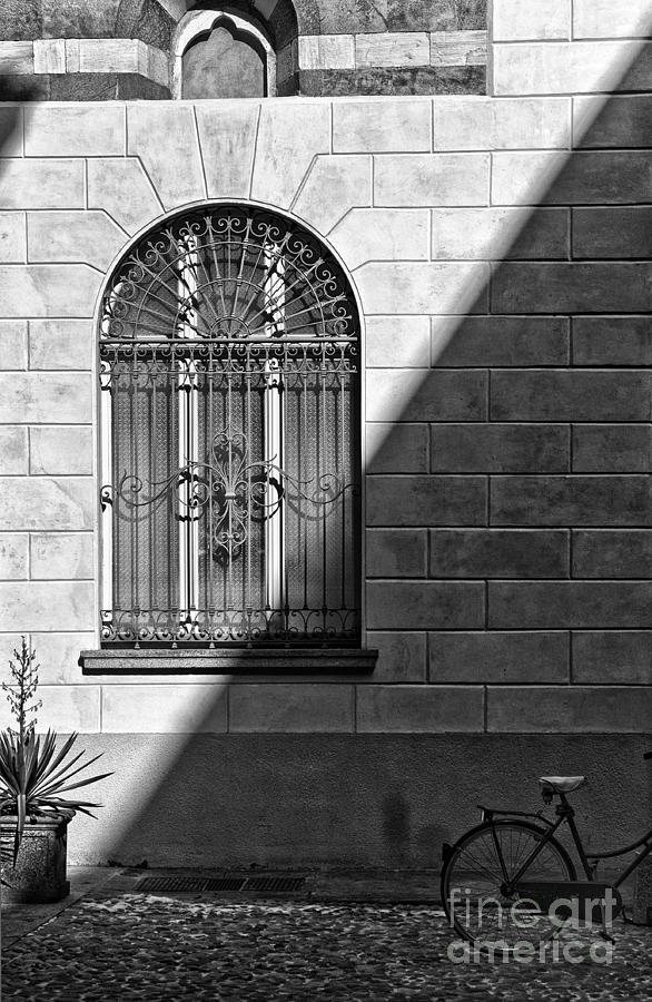 Black And White Photograph - Window and shadow on a wall with bike by Silvia Ganora