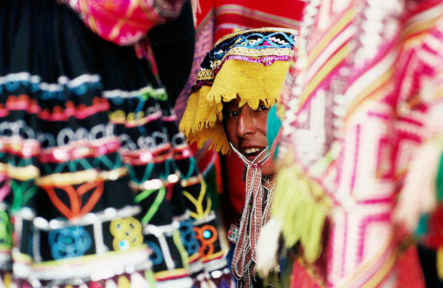 Woman In Traditional Hat Looking Through Textiles And Fabric Of Stall, Peru, South America Photograph by Richard IAnson