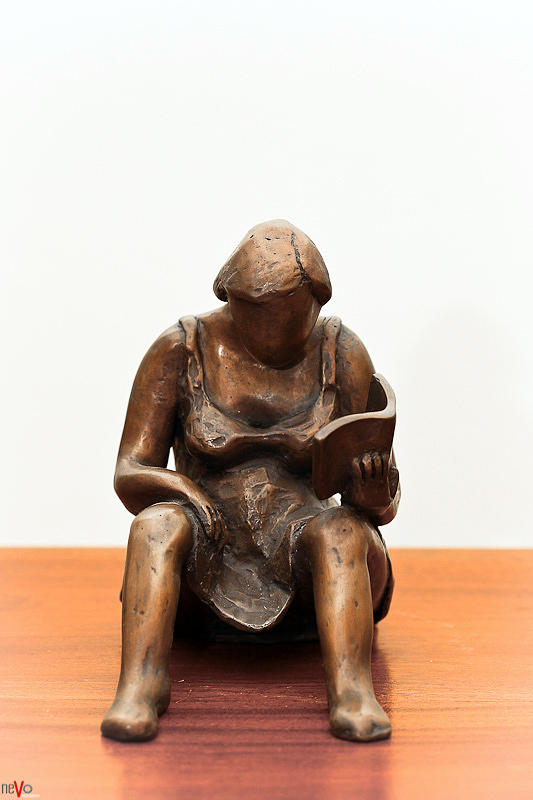 Woman reading a book bronze sculpture dress legs hands pages hair shoulders Sculpture by Rachel Hershkovitz