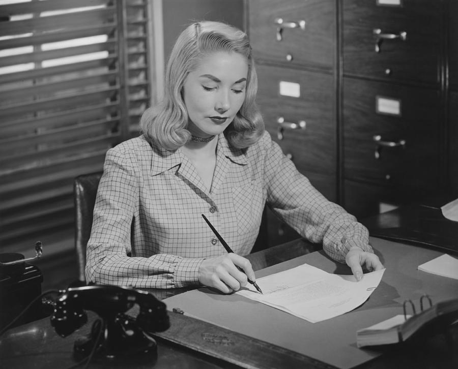 woman-sitting-at-desk-writing-letter-bw-