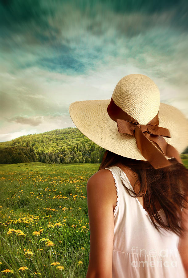 Woman standing with sun hat in a meadow of flowers Photograph by Sandra Cunningham