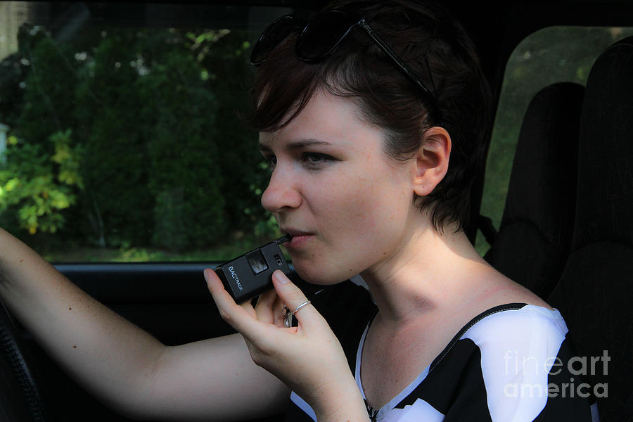 Woman Using A Breathalyzer by Photo Researchers, Inc.