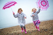 Two Girls On Beach Holding Umbrellas #4 Photograph by Science Photo Library