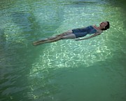 A Model Floating In A Swimming Pool Photograph by John Rawlings